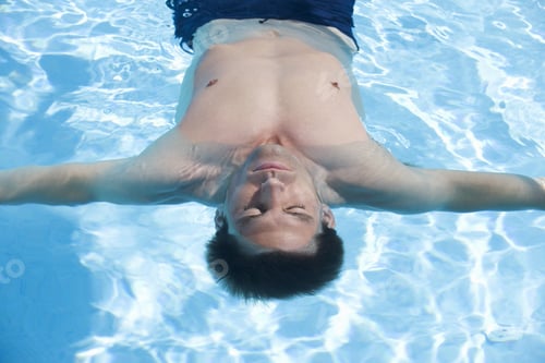 Preview: A Man Relaxing In A Swimming Pool