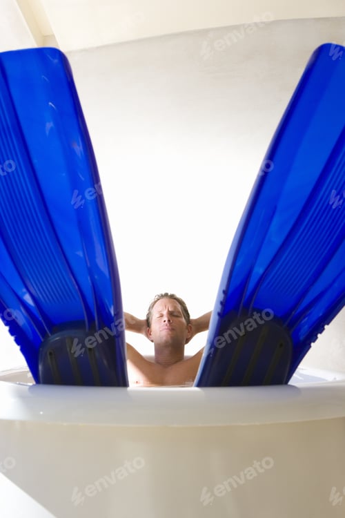 Preview: Man Lying In Bath, Wearing Flippers, Portrait, Flippers In Foreground