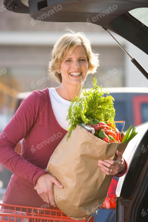 Preview: Portrait Of Mature Woman Loading Grocery Bags In Car At Supermarket