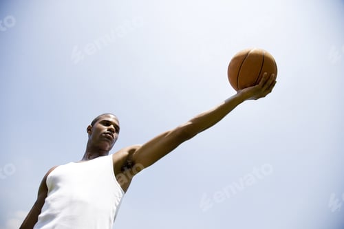 Preview: Young African American Man Holding Out A Basketball, Arm Outstretched