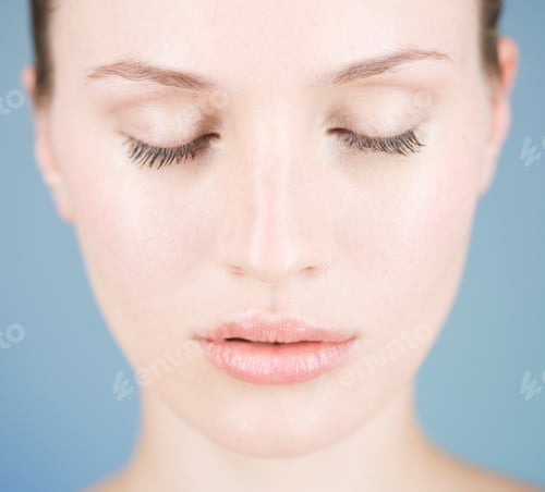 Preview: Studio Portrait Of Beautiful Woman With Closed Eyes Against Blue Background