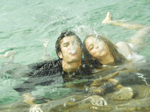 Preview: High Angle View Of A Young Couple Spitting Water In The Sea
