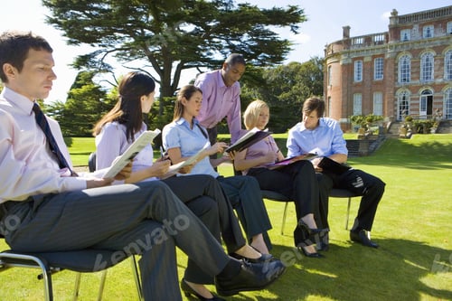 Preview: Group Of Businessmen And Women In Training Course Outdoors By Manor House