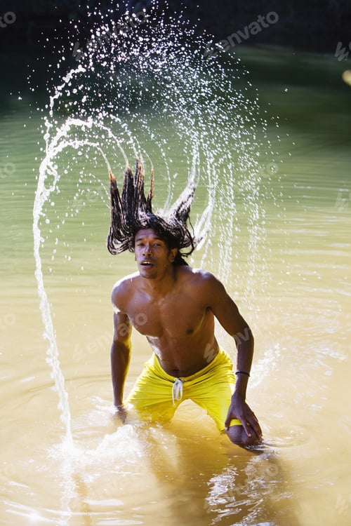 Preview: Man, In Yellow Swimming Shorts, Standing In Shallow Lake, Tossing Back Long, Wet Dreadlocks
