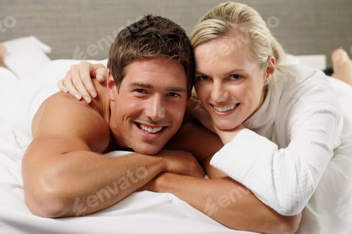 Preview: Portrait Of Couple With Muscle Toned Man With Bare Torso Lying On Bed Smiling At Camera