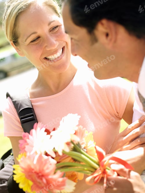 Preview: Romantic Man Giving Smiling Woman Bunch Of Flowers Outdoors