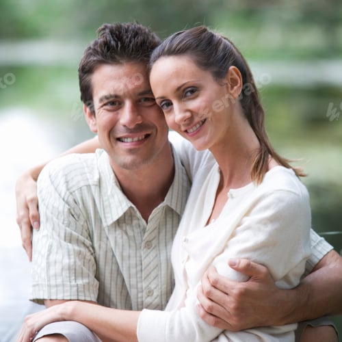 Preview: Loving Young Couple Hugging Sitting By Lake Smiling At Camera