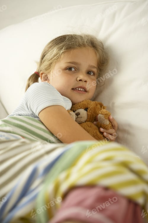 Preview: Side Profile Of A Girl Hugging A Teddy Bear And Lying On The Bed