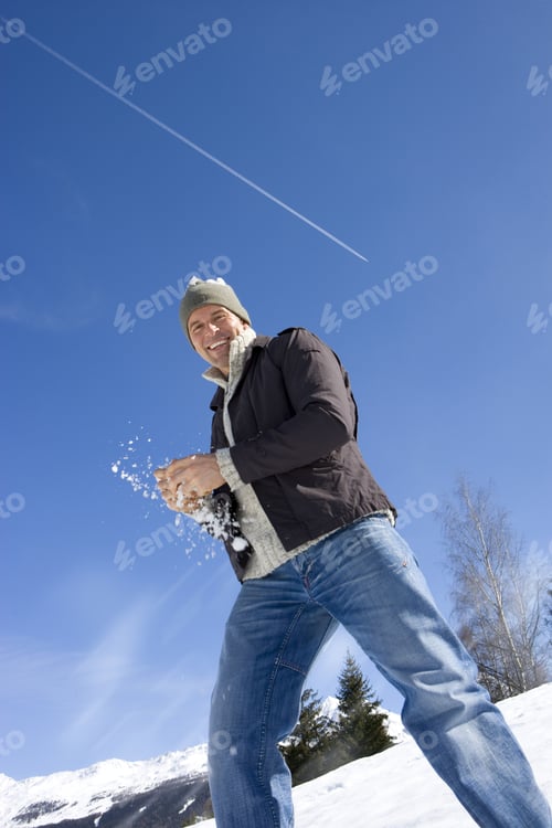 Preview: Young Man Holding Snow Ball In Snow Field, Smiling, Portrait, Low Angle View