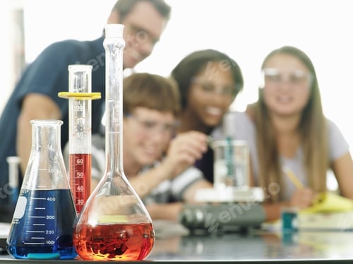 Preview: Teenagers (15-17) Doing Science Experiment, Teacher Assisting, Focus On Conical Flasks In Foreground