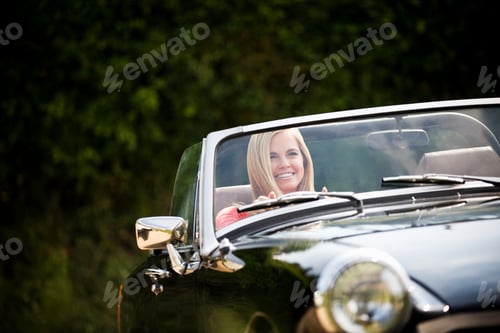 Preview: Young Woman Driving Classic Convertible Black Sports Car Smiling At Camera