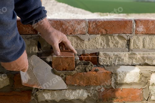 Preview: Detail Of Builder Laying Brick Wall With Trowel And Line