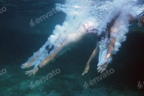 Preview: Side Profile Of Two People Swimming Underwater