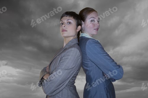 Preview: Businesswomen With Arms Crossed Standing Back To Back