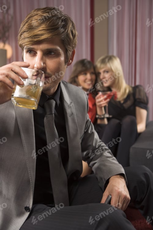 Preview: Man Having A Drink, Women In The Background