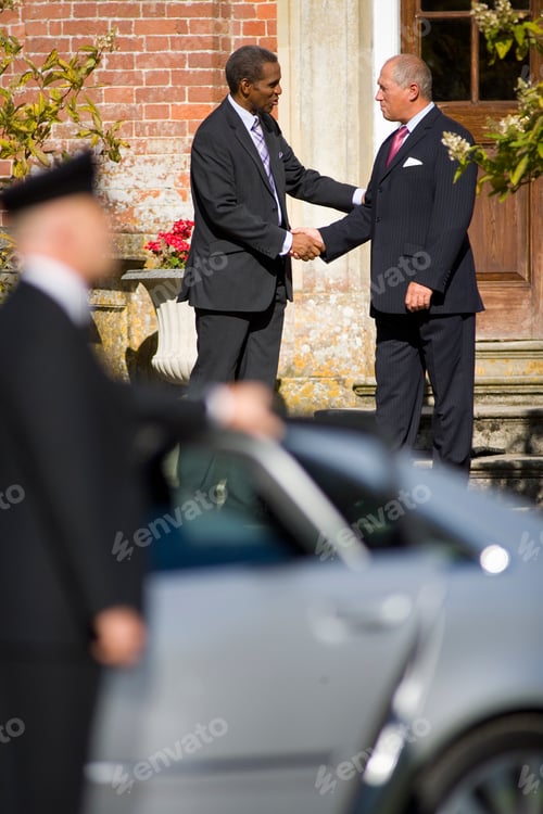 Preview: Chauffeur With Car As Businessmen Shake Hands At Meeting