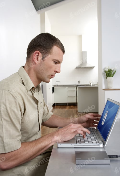 Preview: Man Working on Laptop in Minimalist Home