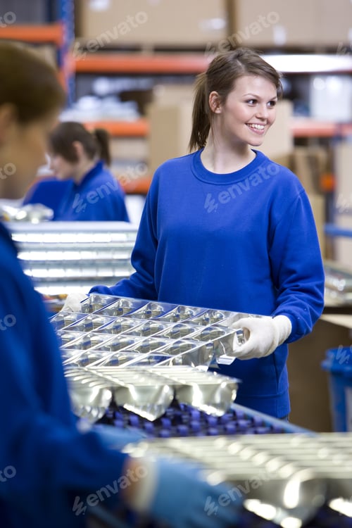 Preview: Smiling Worker Moving Aluminium Light Fittings In Factory