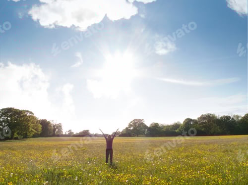 Preview: Woman Standing In Field Of Wild Flowers With Arms Outstretched