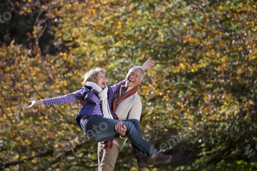 Preview: Laughing Senior Man Carrying Wife In Autumn Park