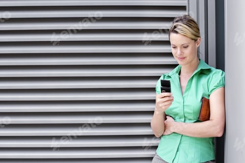Preview: Young Woman In Green Short-Sleeved Blouse Text Messaging On Mobile Phone