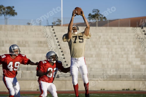 Preview: Opposing American Football Players Competing For Ball During Competitive Game, Offensive Receiver