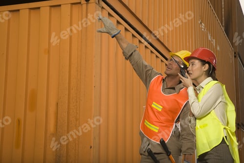 Preview: Male Dock Worker Pointing With His Hand And A Female Dock Worker Talking On A Walkie-Talkie Beside