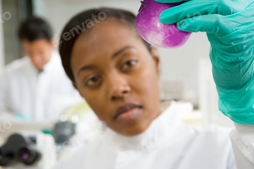 Preview: Female Scientist Holding Genetically Modified Purple Apple