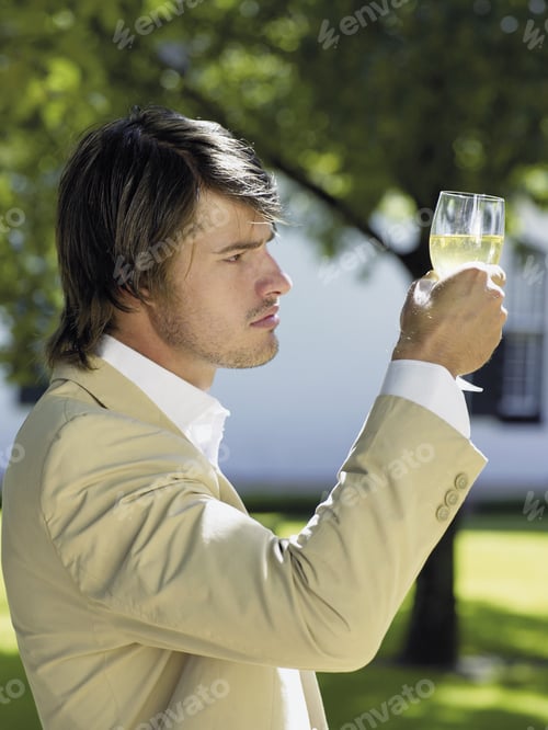 Preview: Man Looking At His Glass Of White Wine.