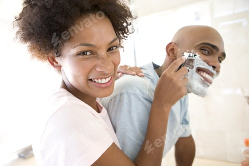Preview: Young Woman Shaving Young Man In Bathroom, Smiling, Portrait