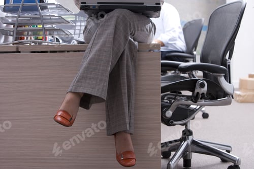 Preview: Businesswoman On Desk With Laptop Computer, Low Section