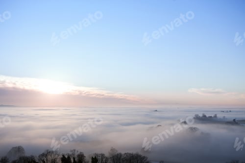 Preview: Sunrise And Blue Sky Over Fog Covered Landscape