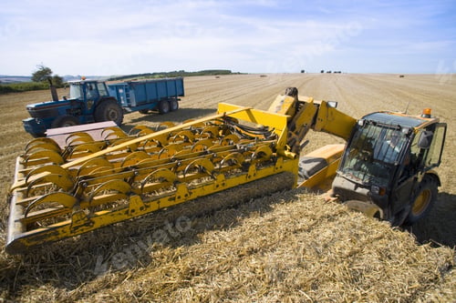 Preview: Tractor Stacking Straw Bales On Trailer In Sunny, Rural Field