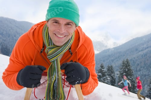 Preview: Man On Winter Vacation Riding Down Snowy Mountain On Sled Smiling At Camera