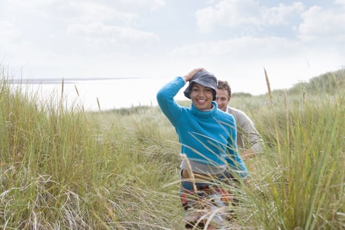 Preview: Young Couple Walking Through Grass At Beach