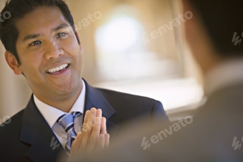 Preview: Respectful Businessman Greeting Counterpart In Building Arcade, Smiling (Differential Focus, Tilt)