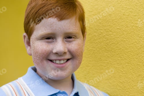 Preview: Boy With Freckles And Ginger Hair Standing Beside Yellow Wall, Smiling, Close-Up, Portrait
