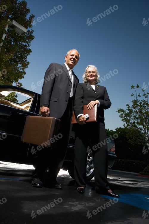Preview: Businessman And Businesswoman Posing Near Car