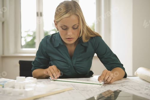 Preview: Young Female Architect Reviewing Blueprints