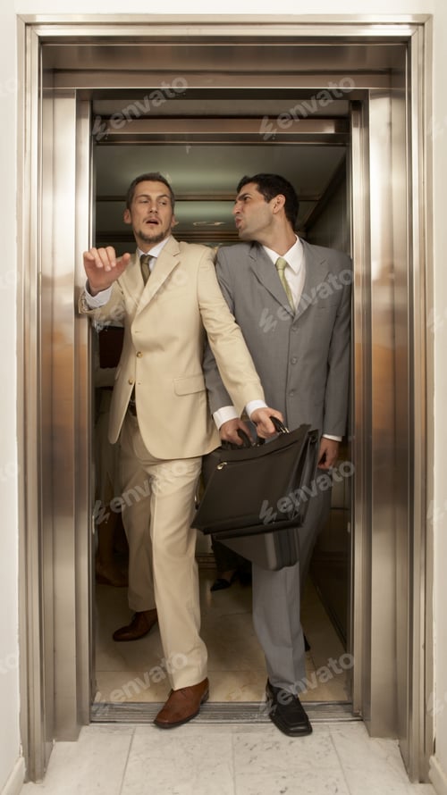 Preview: Two Businessmen Struggling To Get Out Of An Elevator