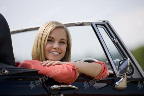 Preview: A Young Woman Sitting In A Black Sports Car
