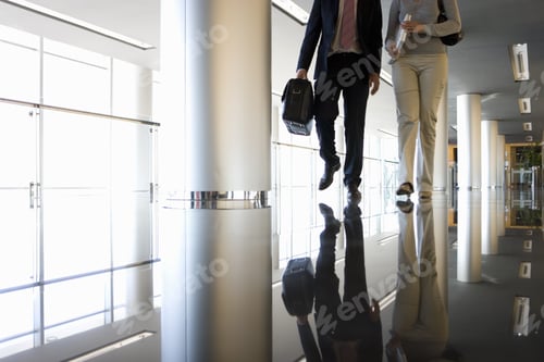 Preview: Businessman And Woman Walking In Corridor, Low Section