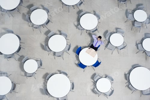 Preview: Businessman Working On Laptop At Table Of Office Canteen