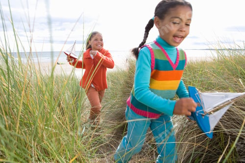 Preview: Girls With Toy Boats On Running Through Sand Dune By Beach In Autumn