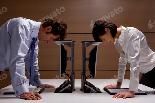 Preview: Frustrated Businessman And Businesswoman Resting Heads On Computers