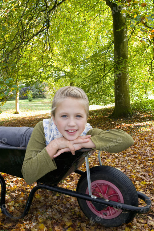 Preview: Portrait Of Girl Laying In Wheelbarrow