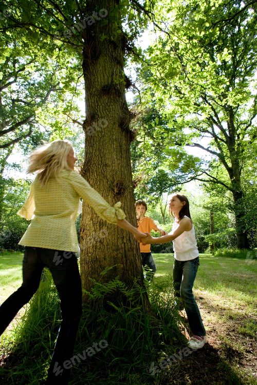 Preview: Family Holding Hands Around Tree In Countryside Loving Nature