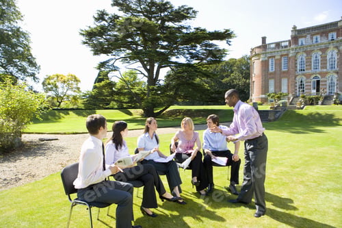 Preview: Group Of Businessmen And Women In Training Course Outdoors By Manor House