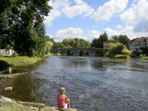 Preview: Tourist Sitting Near River In Bourdeilles, Dordogne, France