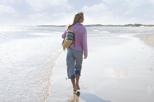 Preview: Young Woman Walking On Beach, Rear View